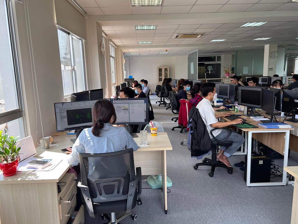 Designers working on CAD drawings at dual-monitor workstations