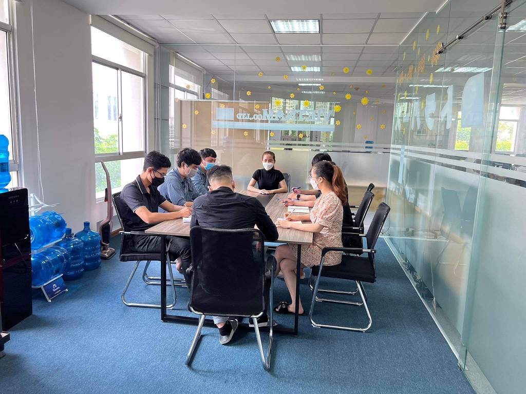Team meeting around a table in a glass-walled meeting room